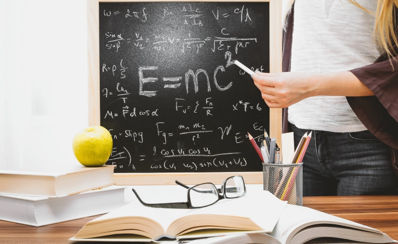 Chalkboard with Einstein's relativity equations including E=mc², illustrating the physics behind time dilation