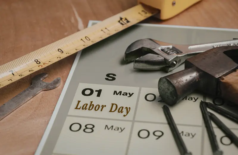 Labor Day marked on a calendar next to work tools