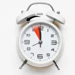 Alarm clock with arrow showing daylight saving time clock change