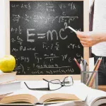 Chalkboard with Einstein's relativity equations including E=mc², illustrating the physics behind time dilation
