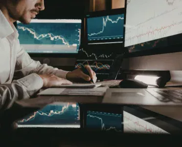 Analyst reviewing market charts at a trading desk