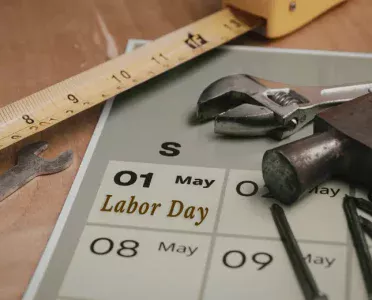 Labor Day marked on a calendar next to work tools